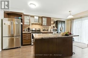 Brantford townhouse for rent - A kitchen with a refrigerator, cabinets, and a countertop.