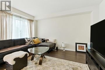 Brantford townhouse for rent - A modern living room with a glass table and a grey couch.