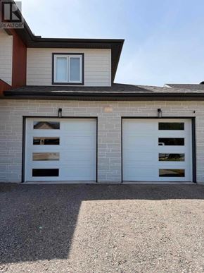 Sault Ste. Marie apartment for rent - A house with two garage doors and a window.