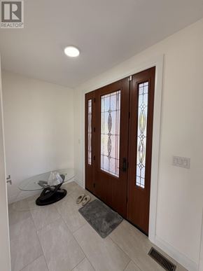 Sault Ste. Marie apartment for rent - A pair of black shoes are on a glass table in front of a wooden door with a glass window.