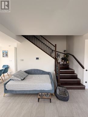 Sault Ste. Marie apartment for rent - A bedroom with a bed, a chair, and a staircase.