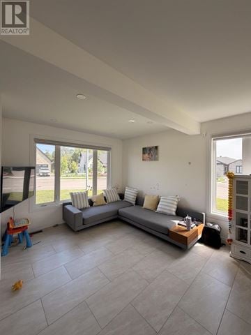Sault Ste. Marie apartment for rent - A spacious living room with a grey sofa and a large window.