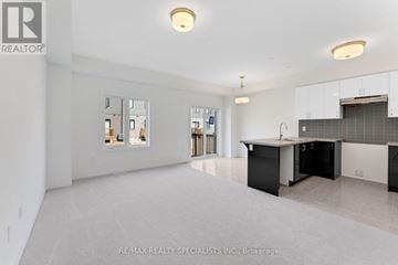 Brantford townhouse for rent - A spacious kitchen with white cabinets and a black island.