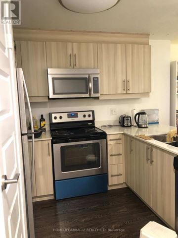 Waterloo condo for rent - A kitchen with a stove top oven and microwave.