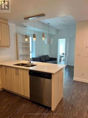 Waterloo condo for rent - A kitchen with wooden cabinets and a stainless steel dishwasher.