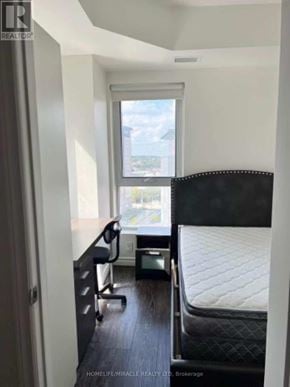 Waterloo condo for rent - A bedroom with a bed, desk, and chair.