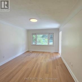 Waterloo apartment for rent - A room with wooden flooring and a window showing greenery outside.