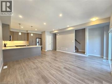 Cambridge townhouse for rent - A spacious living room with a kitchen area in the background.