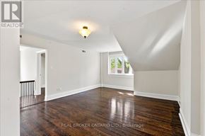 Toronto (Yonge-St. Clair) fourplex for rent - A spacious room with wood flooring and white walls.