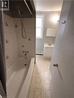 Kitchener condo for rent - A bathroom with a white tub and tiled floor.