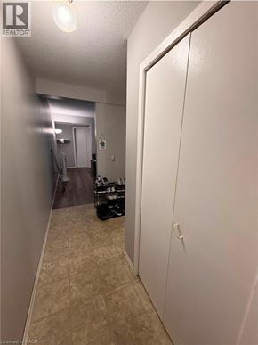 Kitchener condo for rent - A hallway with a white door and a tiled floor.
