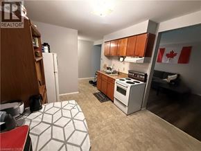 Kitchener condo for rent - A kitchen with a stove, refrigerator, and cabinets.