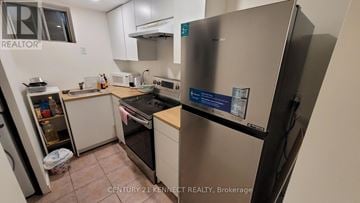 Toronto (Agincourt South-Malvern West) apartment for rent - A kitchen with a refrigerator and a stove top oven.