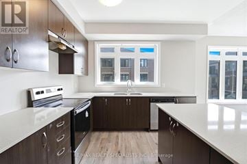 Brantford townhouse for rent - A modern kitchen with dark wood cabinets and white countertops.