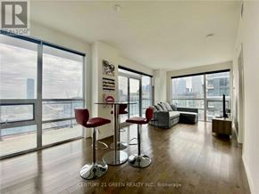 Toronto (Moss Park) condo for rent - A living room with a bar stool and a couch.