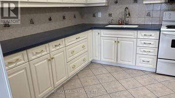 Toronto (Mount Dennis) condo for rent - A kitchen with white cabinets and a black countertop.