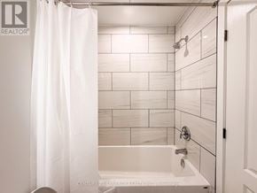 Carleton Place apartment for rent - A white bathroom with a shower curtain and a bathtub.