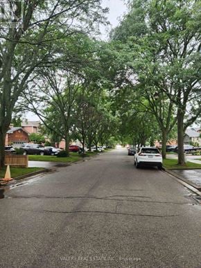 Ajax (Central West) apartment for rent - A residential street with cars parked on the side and trees lining the road.