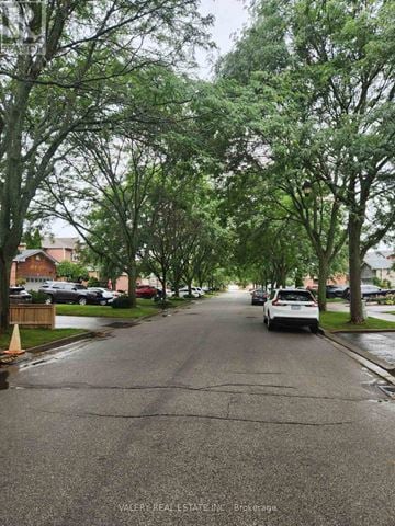Ajax (Central West) apartment for rent - A residential street with cars parked on the side and trees lining the road.