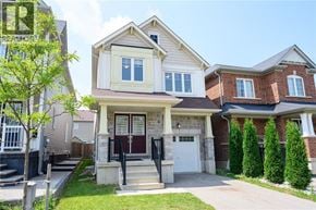 Caledonia apartment for rent - A house with a red door and white garage door is surrounded by a well-maintained lawn and a sidewalk.