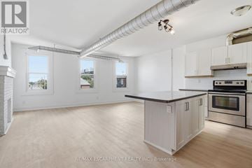 Hamilton (Stipley) townhouse for rent - A kitchen with white cabinets and a black countertop.