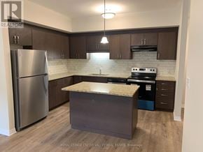 Cambridge townhouse for rent - A kitchen with a refrigerator, stove, and island.