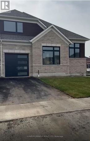 Adjala-Tosorontio (Colgan) townhouse for rent - A brick house with a black garage door is for sale.