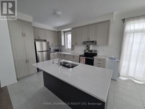 Adjala-Tosorontio (Colgan) townhouse for rent - A kitchen with a white countertop and a stainless steel refrigerator.