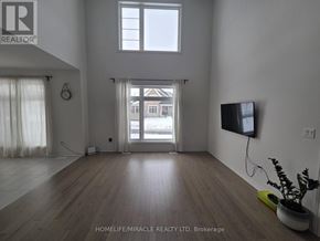 Adjala-Tosorontio (Colgan) townhouse for rent - A living room with wooden floors and a flat screen TV mounted on the wall.