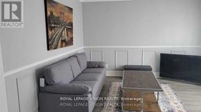 Tweed (Tweed (Village)) apartment for rent - A living room with a grey sofa and a painting of a bridge on the wall.