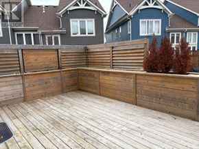 Collingwood townhouse for rent - A wooden deck with a fence and a tree in the background.