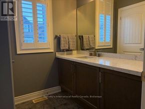 Collingwood townhouse for rent - A bathroom with a sink, mirror, and a window.