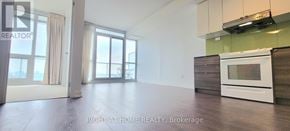 Toronto (Bayview Village) condo for rent - A spacious kitchen with a white oven and wooden cabinets.