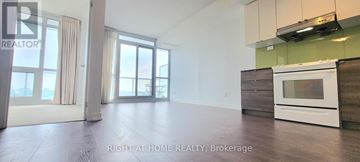 Toronto (Bayview Village) condo for rent - A spacious kitchen with a white oven and wooden cabinets.
