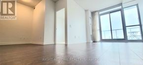 Toronto (Bayview Village) condo for rent - A spacious room with a large window and sliding glass doors.
