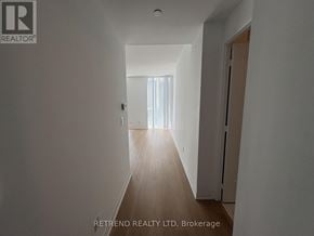 Toronto (Mount Pleasant West) condo for rent - A long hallway with a door on the right and a window with curtains on the left.