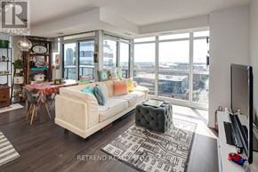 Toronto (Moss Park) condo for rent - A living room with a large window overlooking the city.