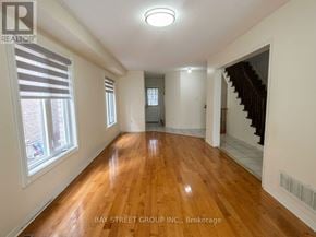 Markham (Cedarwood) apartment for rent - A spacious room with wooden floors and white walls, part of a Bay Street Group Inc. property.