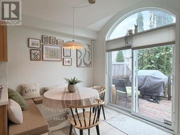 Ottawa townhouse for rent - A living room with a white table and a couch with a green pillow on it.