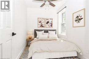 Hamilton apartment for rent - A bedroom with a bed, a ceiling fan, and two framed pictures on the wall.