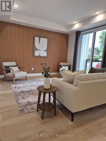 Ottawa multi-family for rent - A living room with a white couch, a wooden coffee table, and a large window.