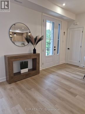 Ottawa multi-family for rent - A realtor photo of a room with a wooden fireplace and a round mirror on the wall.
