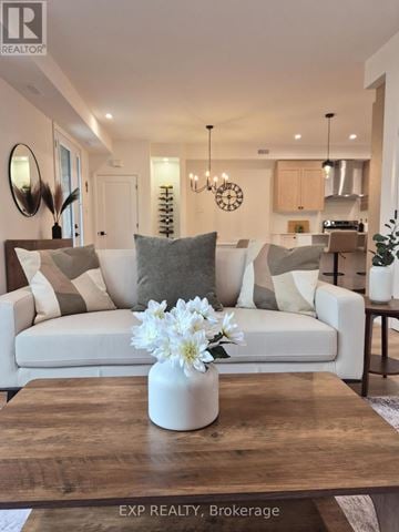 Ottawa multi-family for rent - A modern living room with a white sofa and a coffee table with a vase of flowers on it.