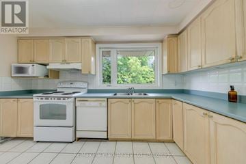 Oakville (Sw Southwest) apartment for rent - A kitchen with wooden cabinets and white appliances.