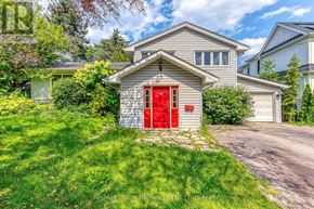 Oakville (Sw Southwest) apartment for rent - A house with a red door is surrounded by greenery.