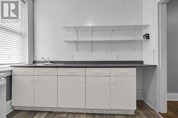 St. Thomas duplex for rent - A kitchen with white cabinets and a black countertop.