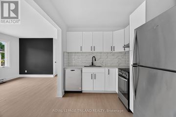 London South (South D) multi-family for rent - A kitchen with white cabinets and a refrigerator.