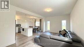 London North (North S) apartment for rent - A living room with a grey couch and a kitchen area in the background.
