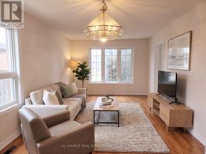 Barrie (Painswick South) apartment for rent - A well-lit living room with a couch, chair, and television.