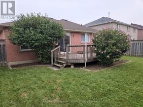 Barrie (Painswick South) apartment for rent - A backyard with a deck and a tree.